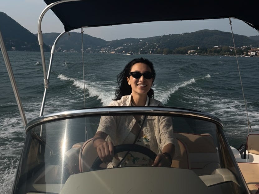 Une femme portant des lunettes de soleil conduisant un bateau sur le lac de Côme, en Italie.