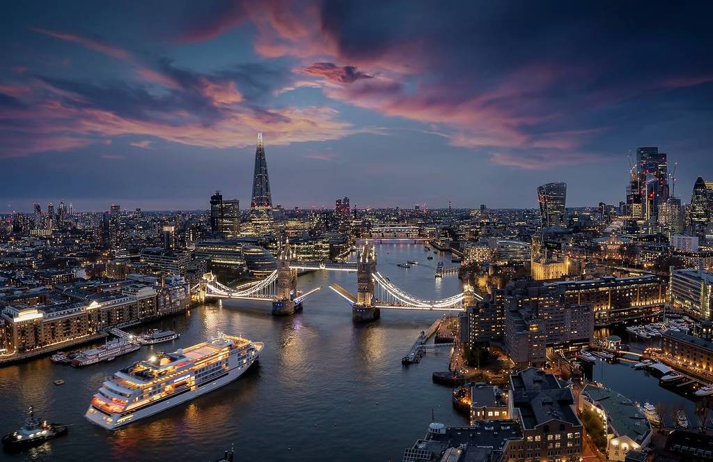 Vue panoramique de la skyline de Londres avec un bateau de croisière passant sous le Tower Bridge